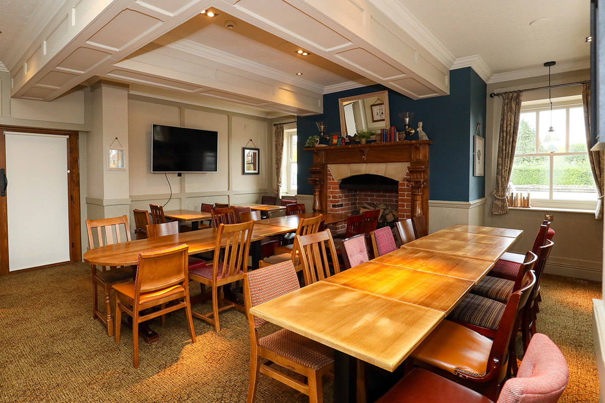 Meeting room at Toby Carvery Quinton with cozy fireplace for team-building events.