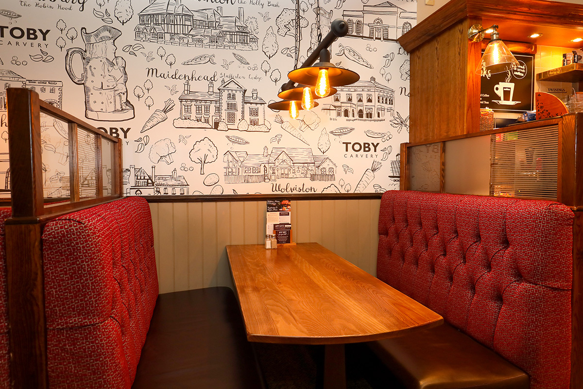 Cozy meeting room with plush red booths at Toby Carvery Quinton, ideal for small gatherings.