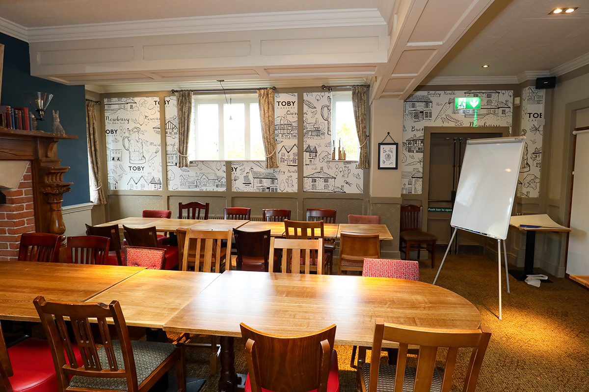 Versatile meeting room with wooden tables, ideal for workshops and corporate meetings.