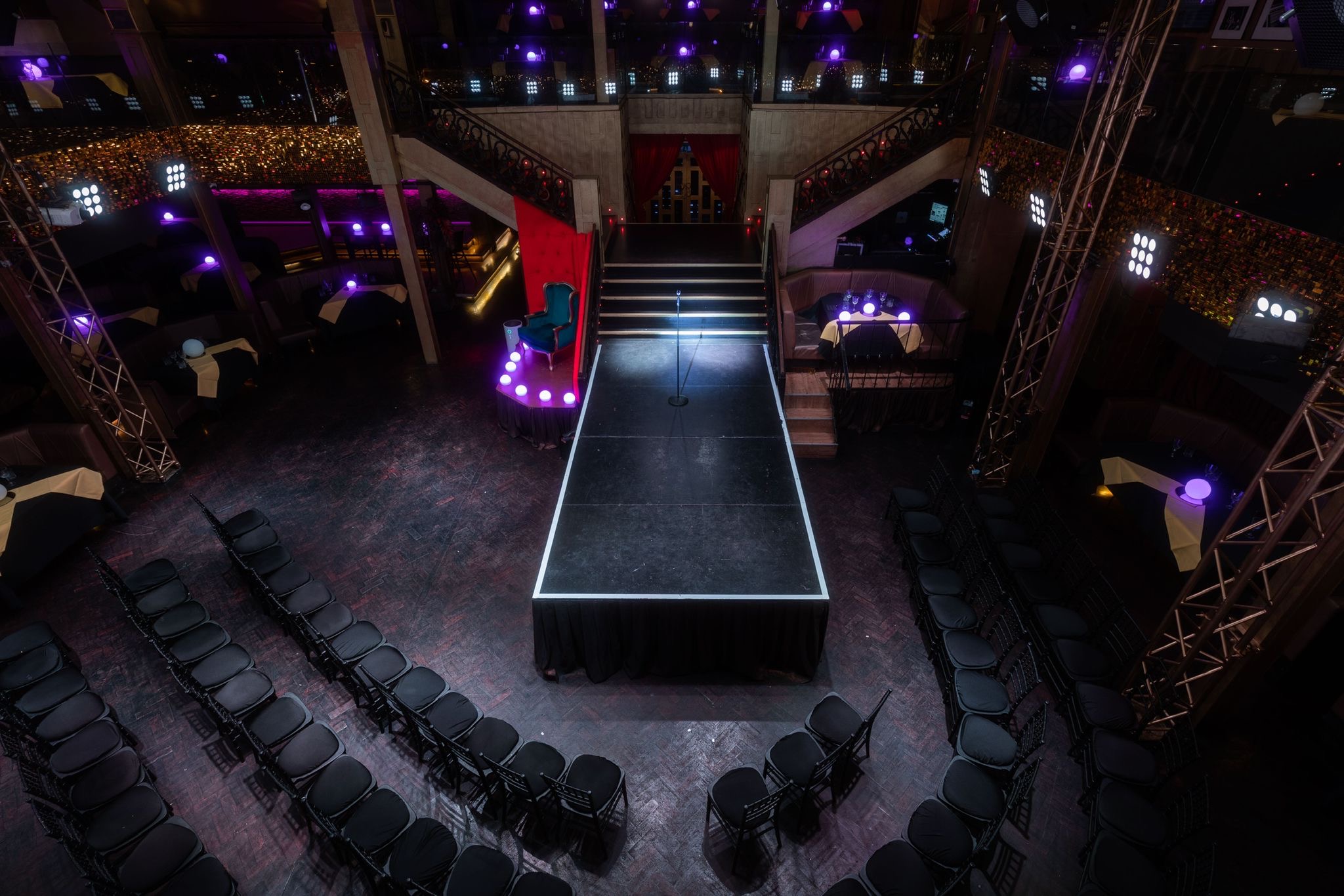 Versatile event space with runway and black chairs, perfect for fashion shows and corporate events.