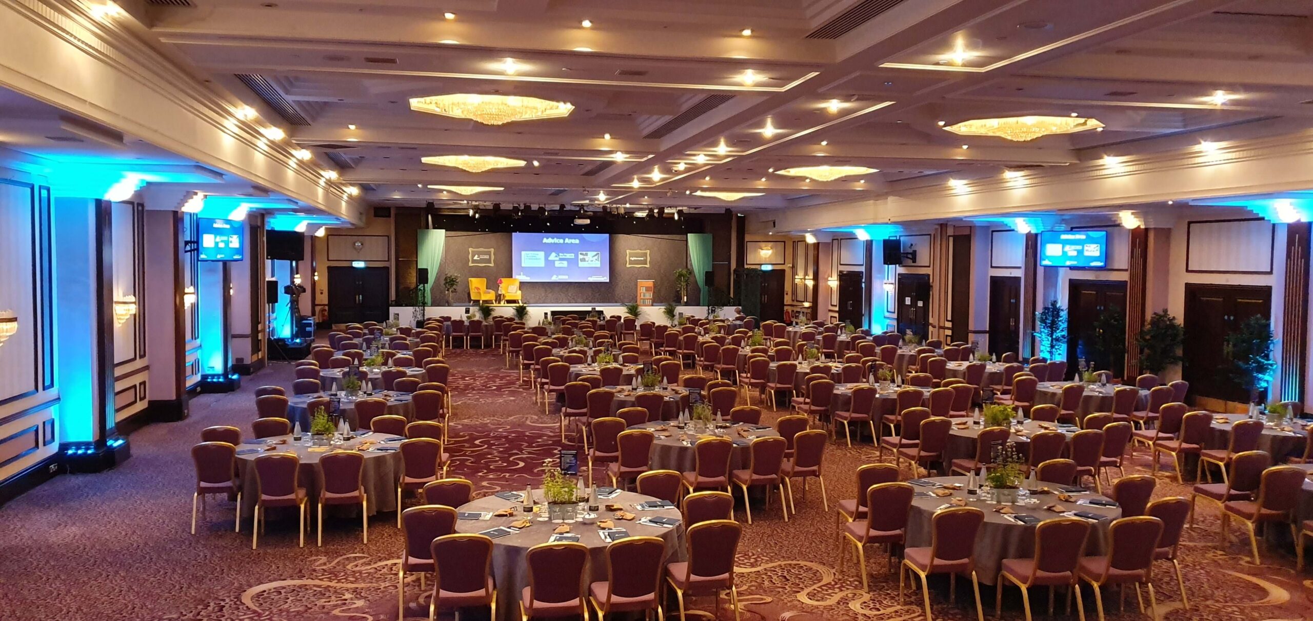 Elegant Prestige Suite event space with round tables, ideal for conferences and galas.