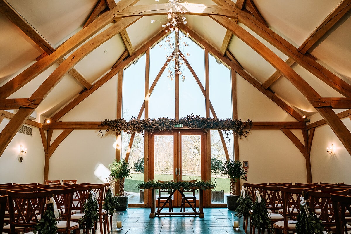 Ceremony space in Mythe Barn with wooden beams, ideal for weddings and gatherings.