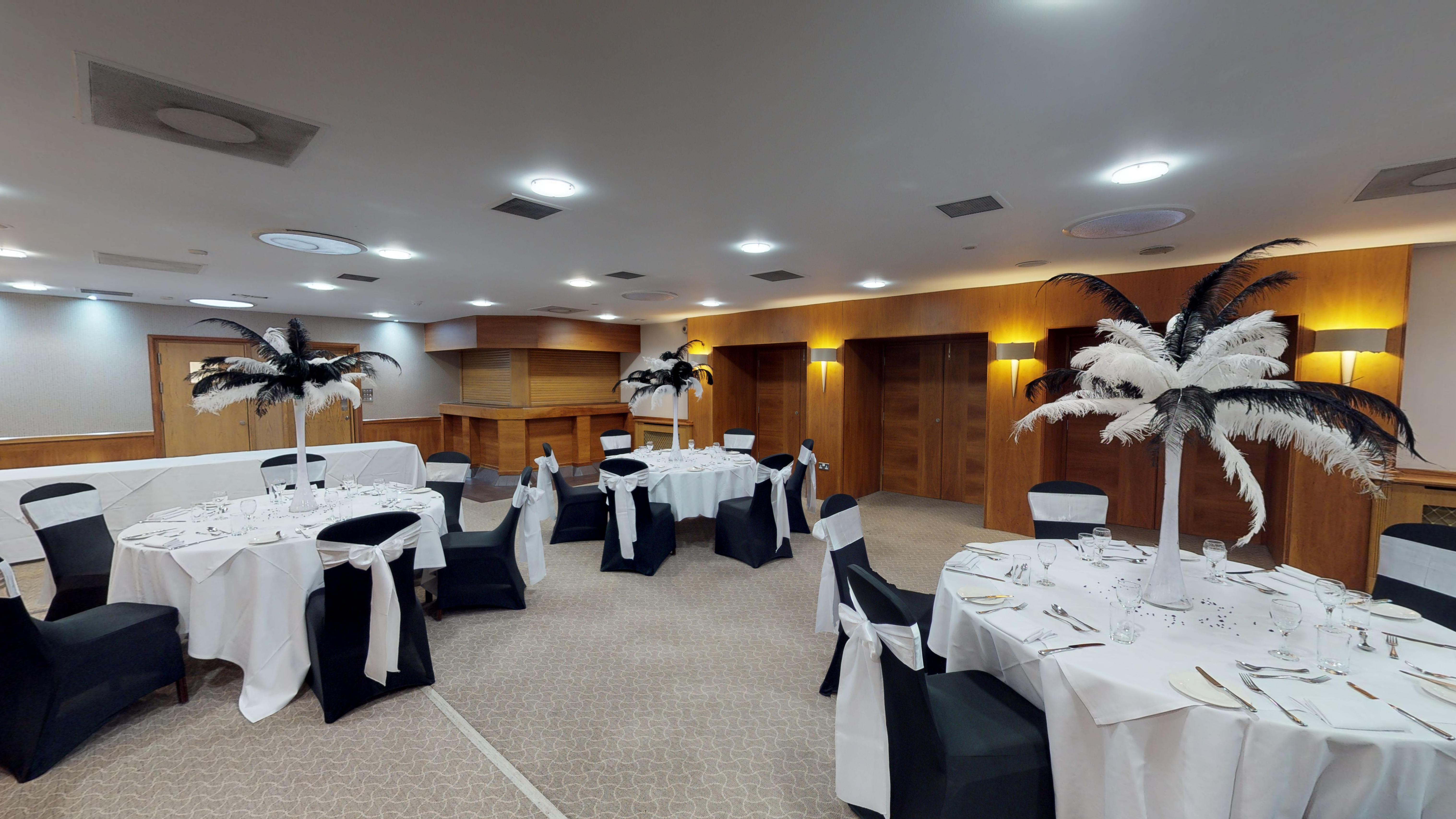 Elegant banquet room at Lea Marston Hotel with feather centerpieces for upscale events.