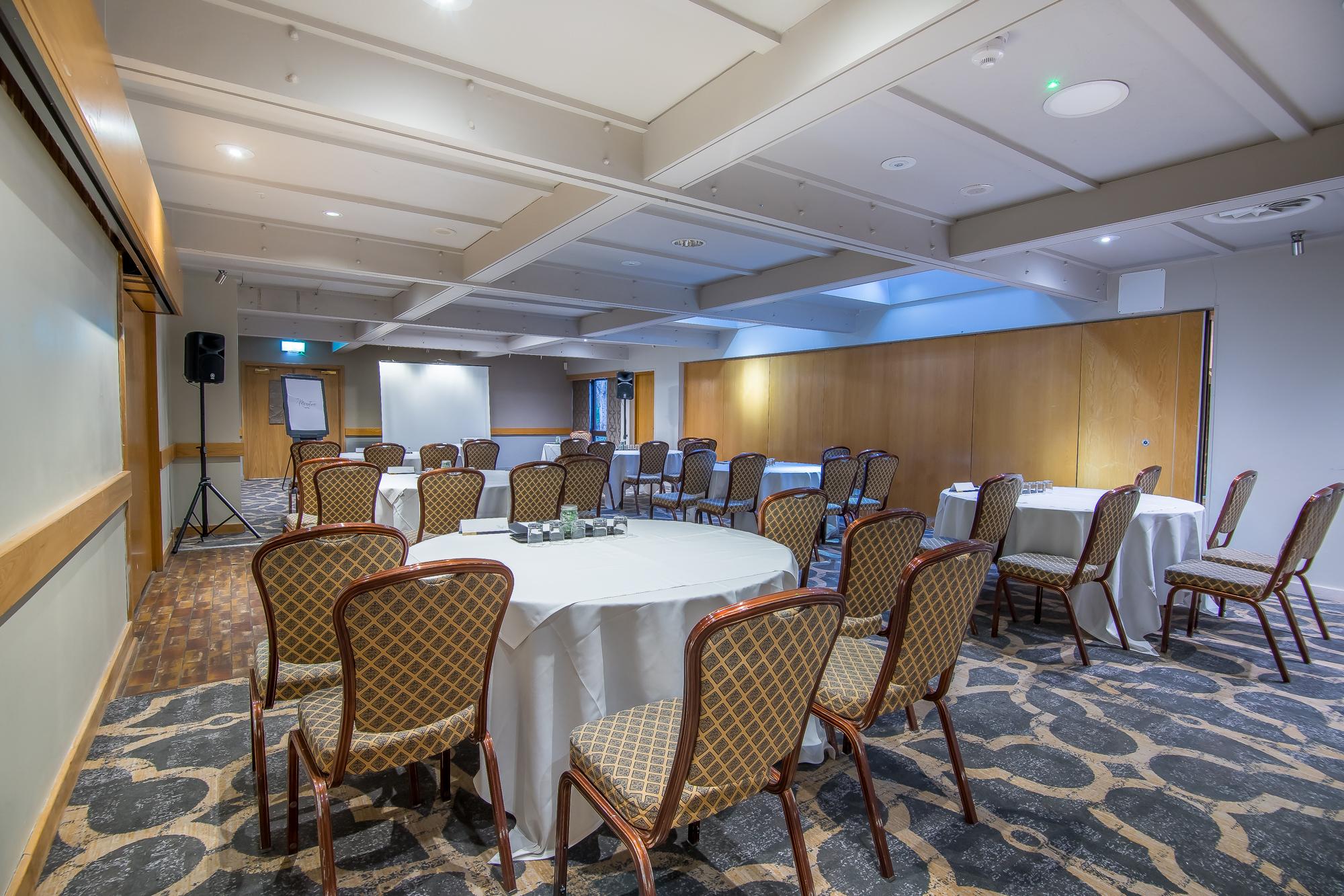 Dunton Conference Suite with circular tables, ideal for corporate meetings and workshops.