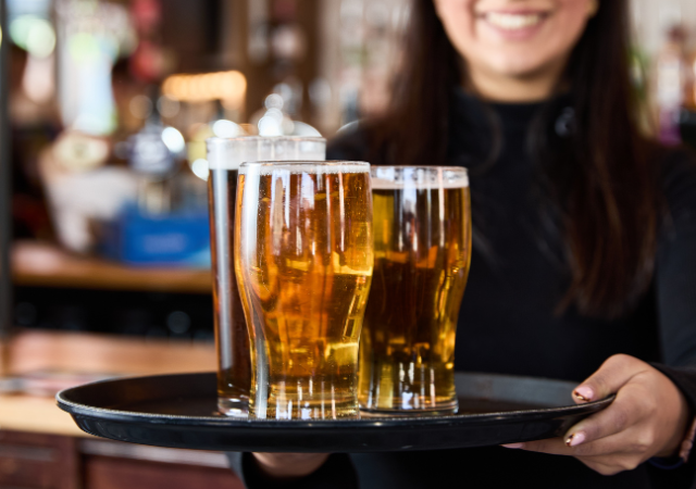 Server presenting a tray of craft beers at Great Stone Inn Birmingham event space.