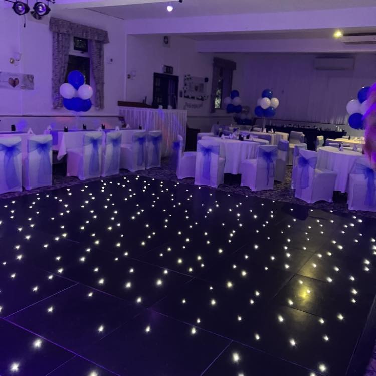 Elegant event space at Rattlers Club with blue-sashed tables, ideal for weddings.