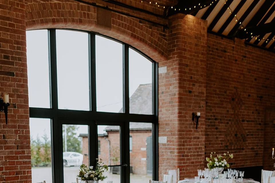 Rustic event space with exposed brick, ideal for weddings and corporate gatherings.