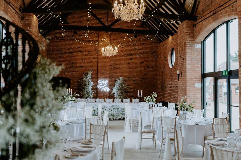 Elegant event space in The Barn with rustic decor, ideal for weddings and gatherings.