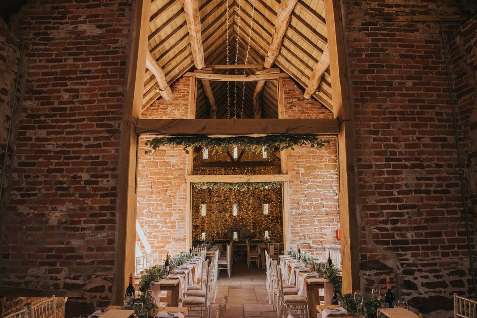 Rustic outdoor wedding venue with exposed brick and wooden beams, perfect for celebrations.