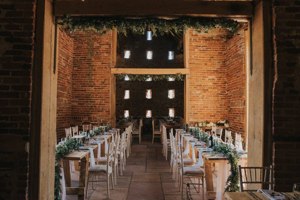 Outdoor wedding ceremony spot with rustic brick walls and elegant table settings.