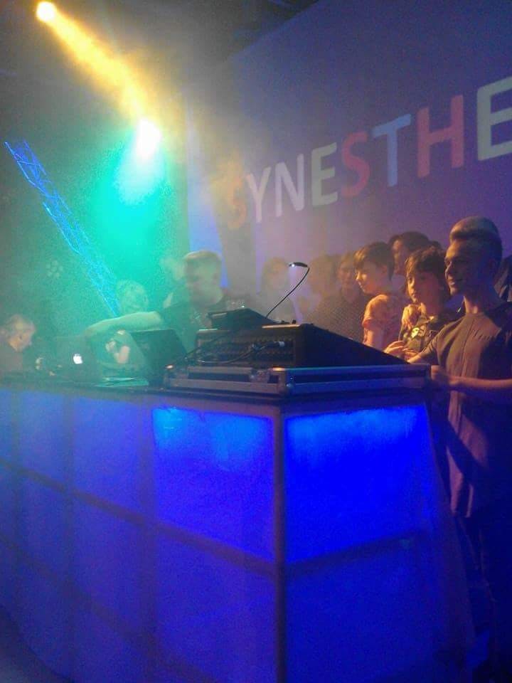 DJ performing in Dovehouse Theatre auditorium with vibrant lighting for nightlife event.