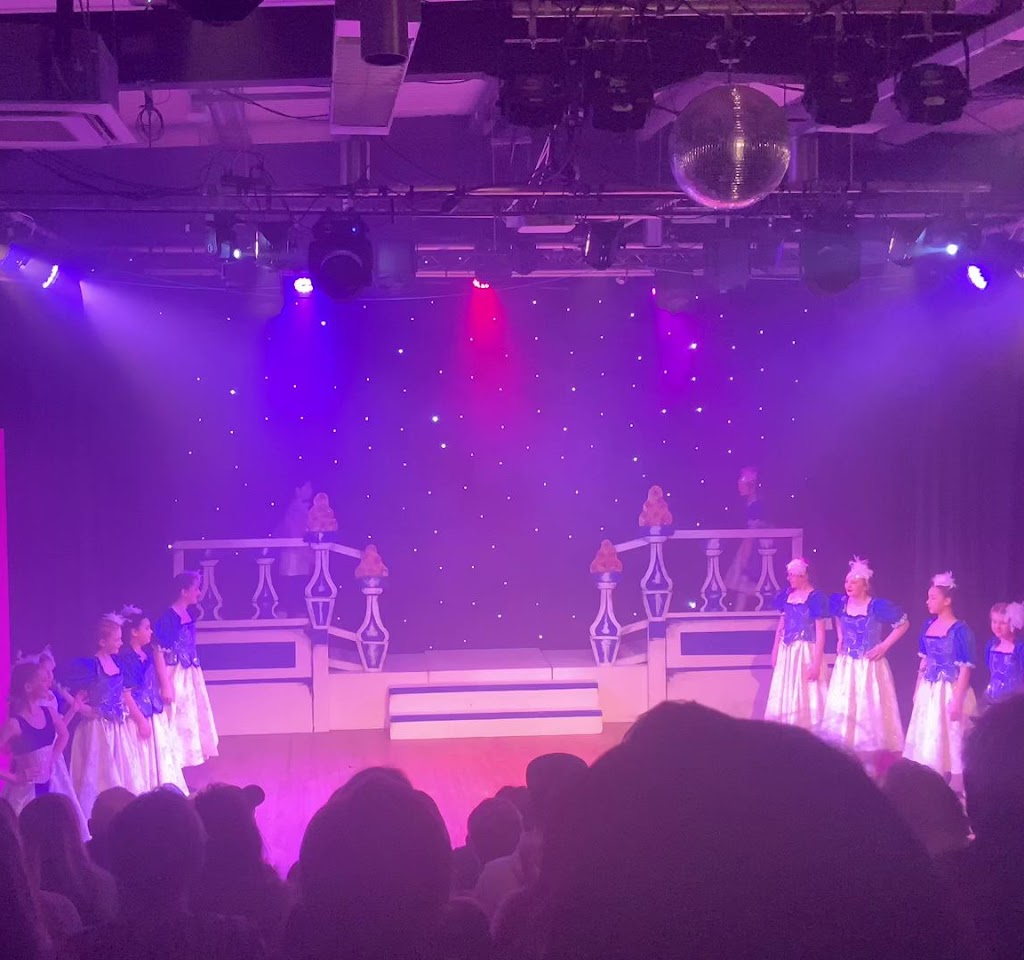 Vibrant stage with young dancers at Dovehouse Theatre for a recital or theatrical performance.