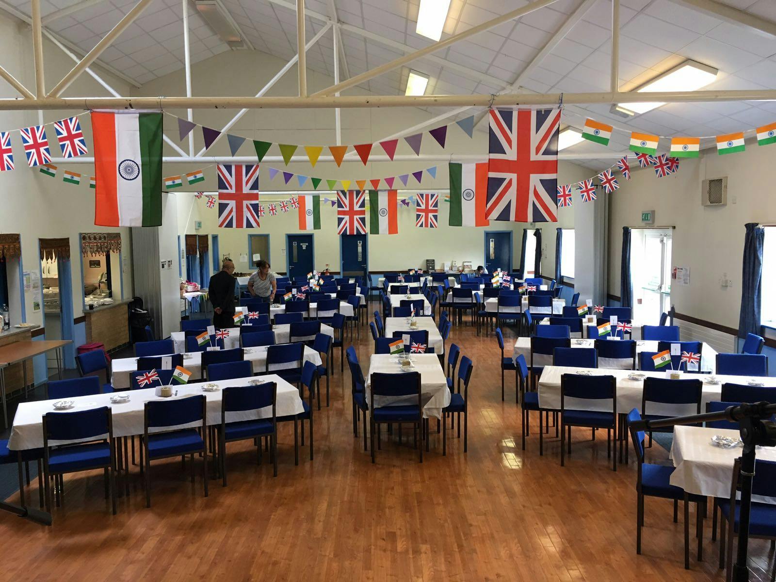 Committee Room at Layca Community Centre, vibrant multicultural event space with colorful flags.