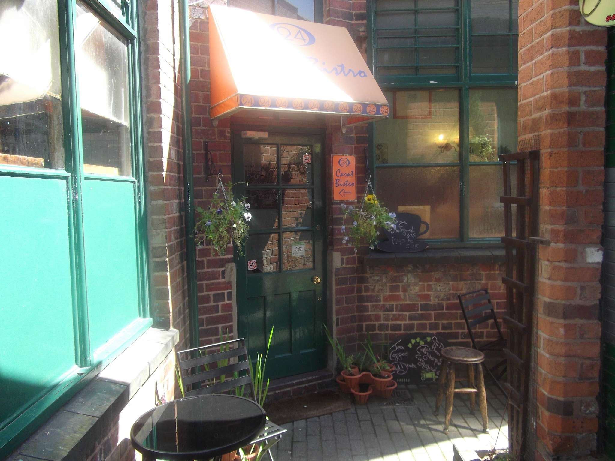 Charming 24K Bistro entrance with greenery, perfect for intimate gatherings and workshops.