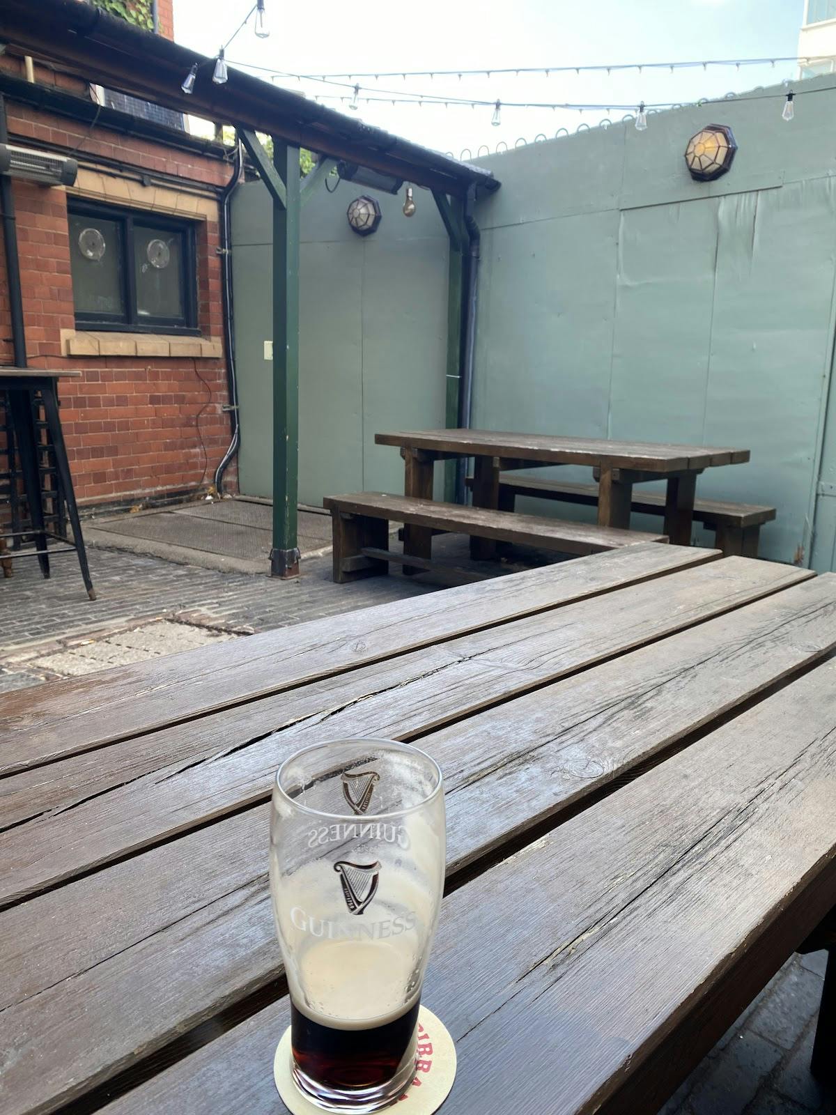 Rustic outdoor garden area with wooden picnic tables for casual gatherings and networking events.