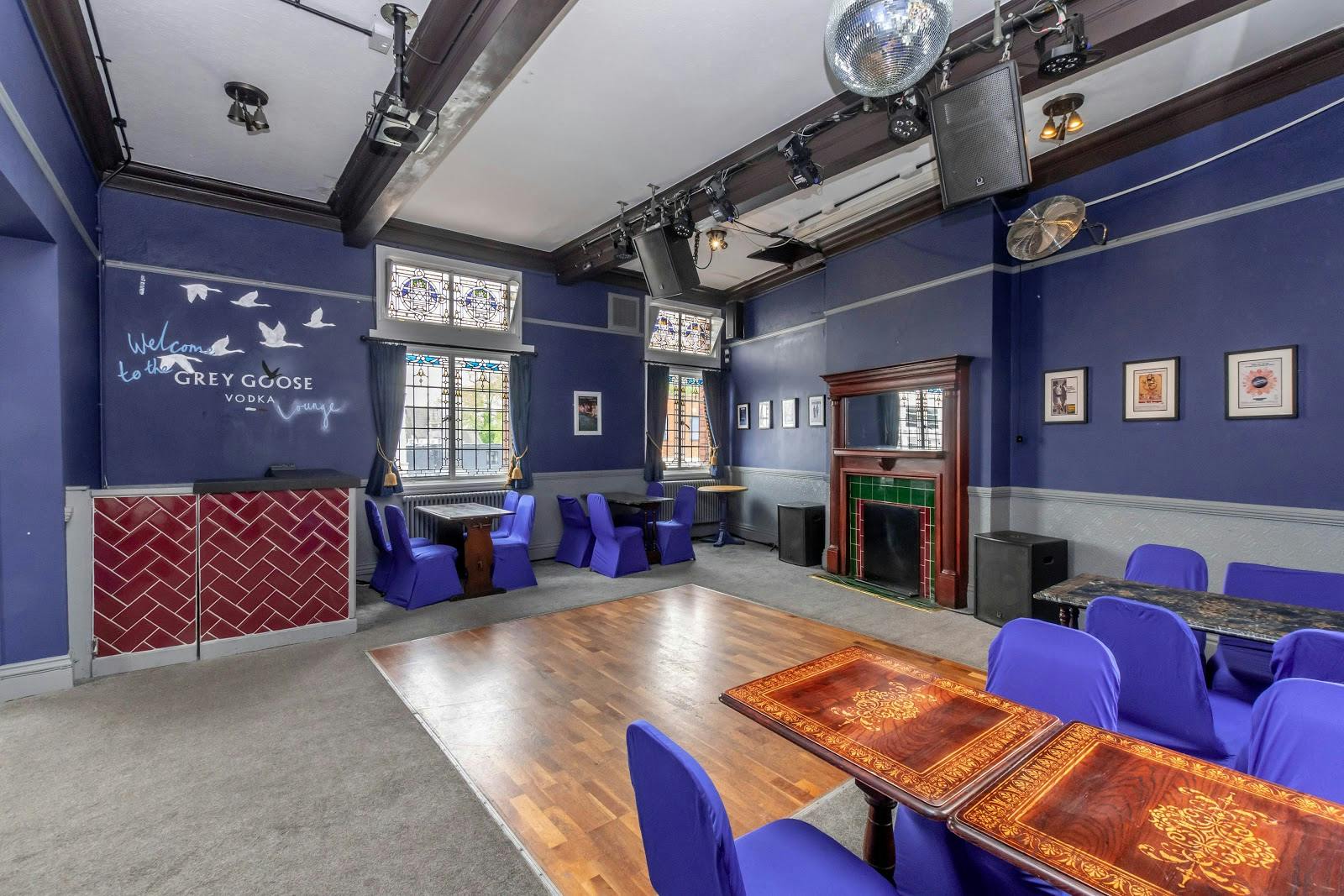 Stylish garden event space with deep blue walls, perfect for gatherings and presentations.