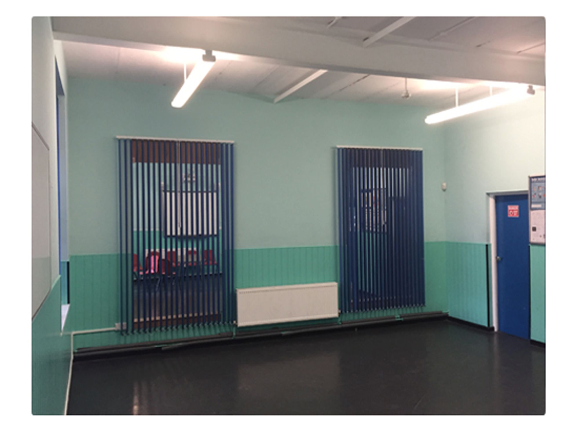 Versatile event space in Quinborne Community Centre with calming blue-green decor.