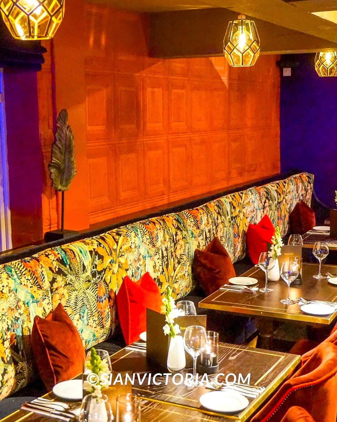 Gastropub dining setup with floral banquette, ideal for upscale events and private dinners.