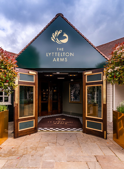 Elegant entrance of The Lyttelton Arms bar with floral decor, ideal for upscale events.