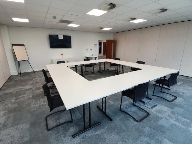 Modern training room with large table, ideal for workshops and meetings.