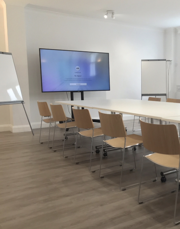 Modern meeting room in St Pauls Knightsbridge with large screen for presentations.