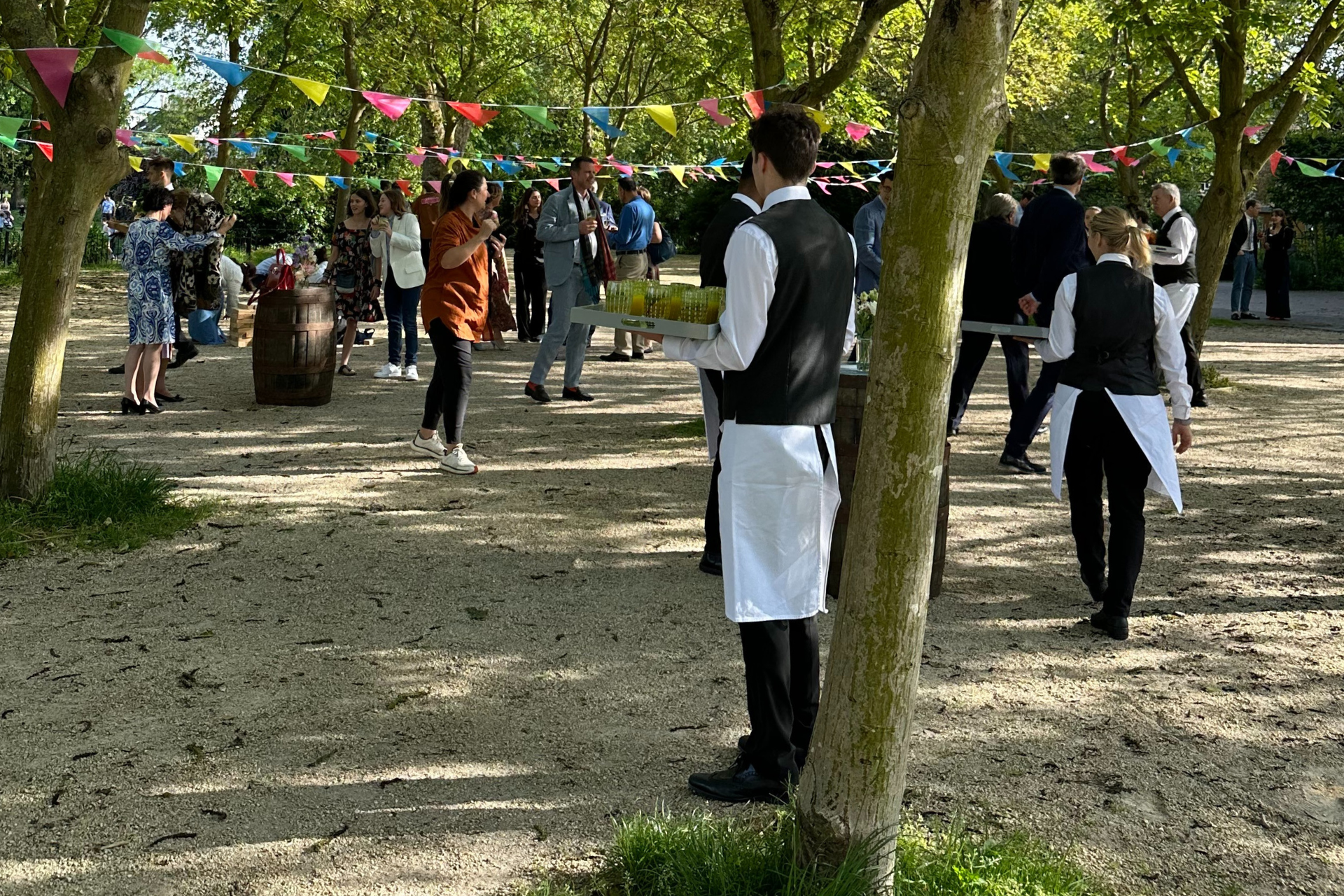 Vibrant outdoor event in Sands End courtyard with guests and colorful bunting.