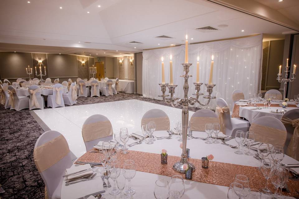 Elegant banquet space with rose gold decor, ideal for weddings and corporate events.