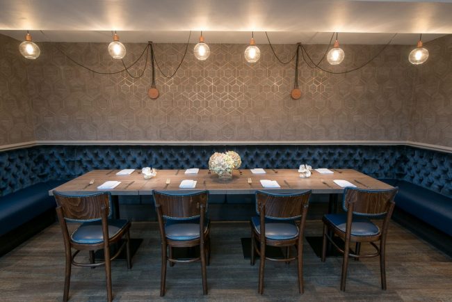 Stylish restaurant meeting space with elegant table and plush blue banquette in Westmead Hotel.