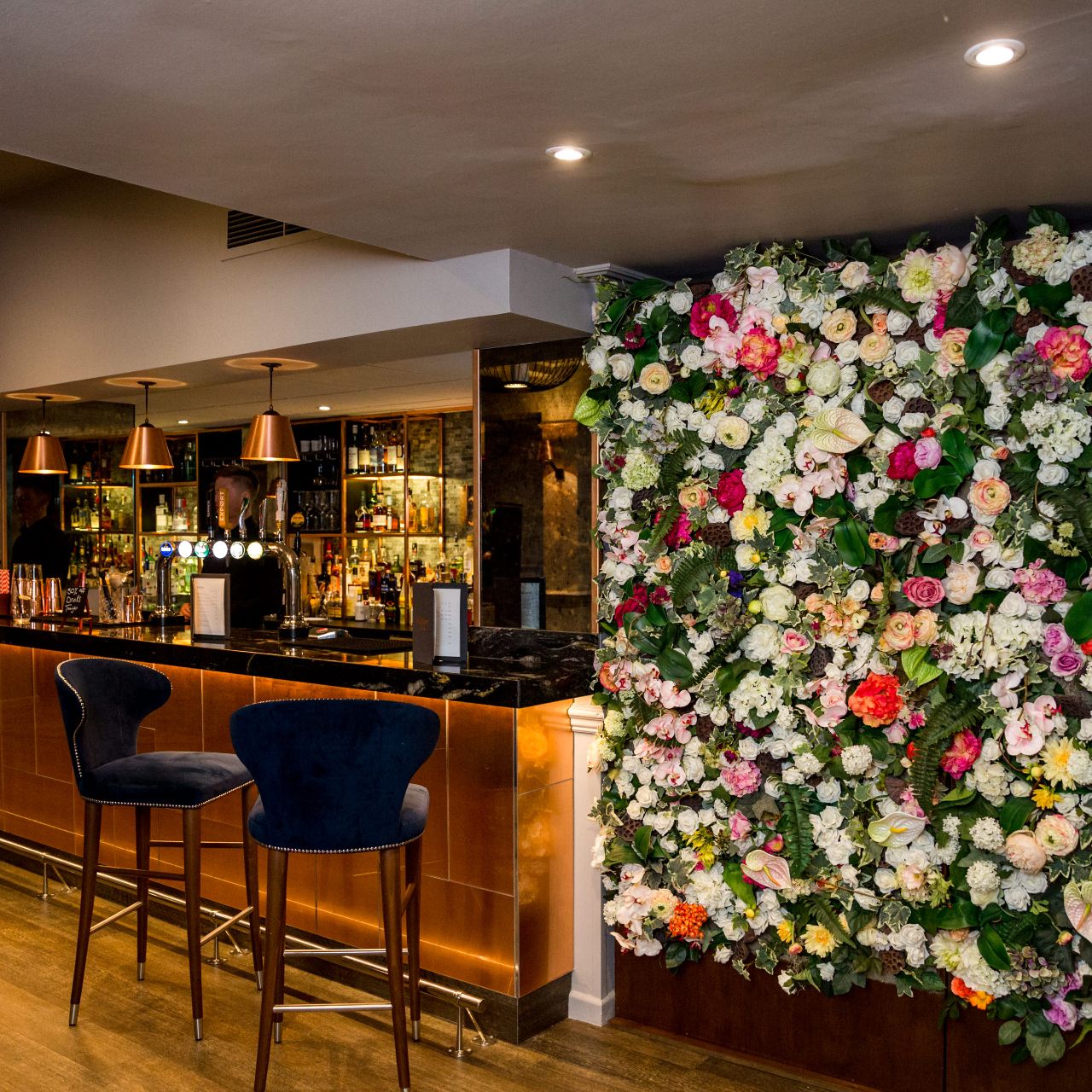 Stylish Westmead Hotel bar with floral wall, perfect for events and celebrations.
