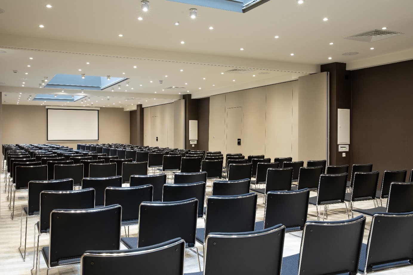 Spacious conference room with black chairs, ideal for presentations and workshops.