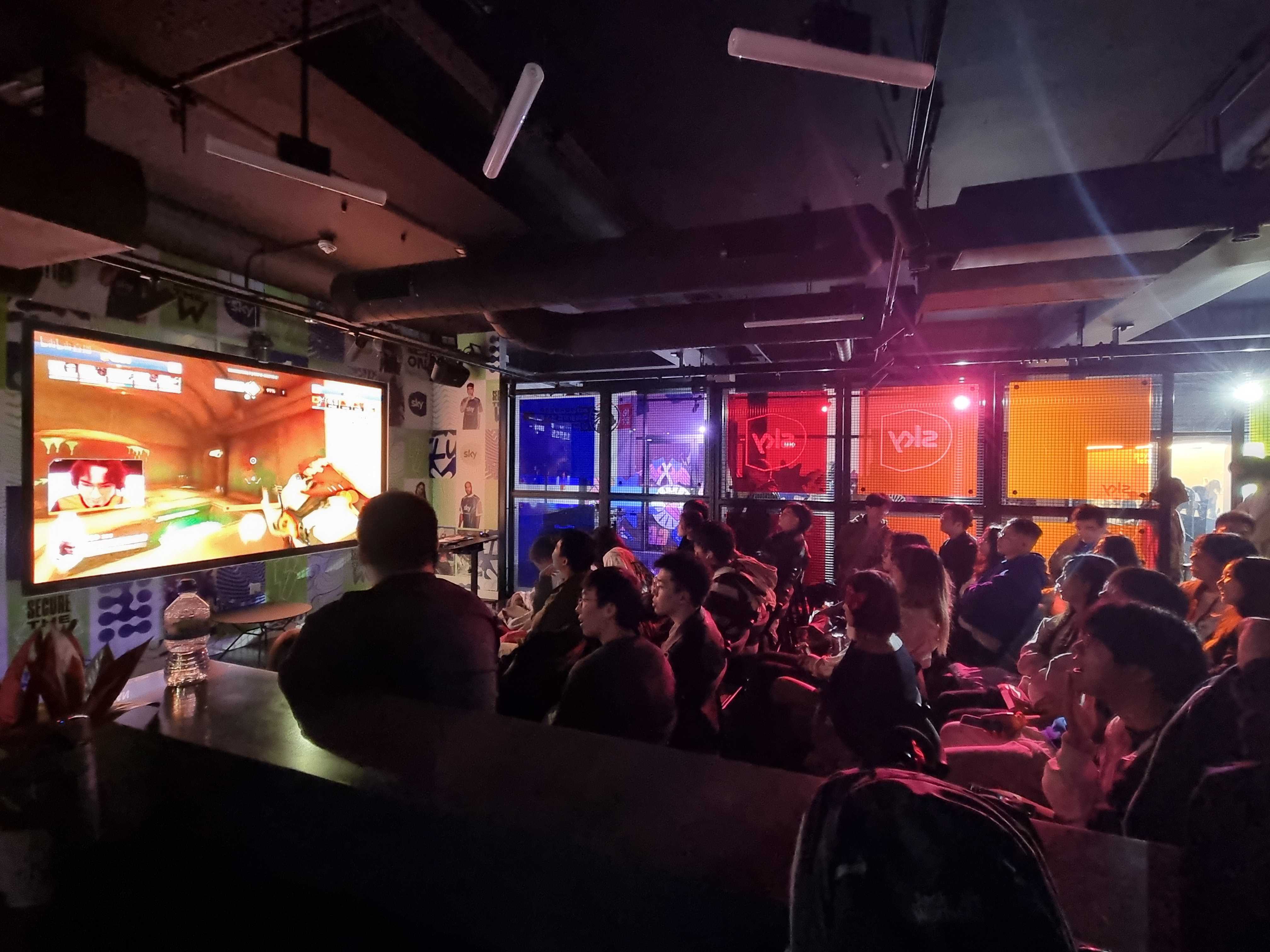 Vibrant esports event space with large screen and colorful lighting at Sky Guild Gaming Centre.