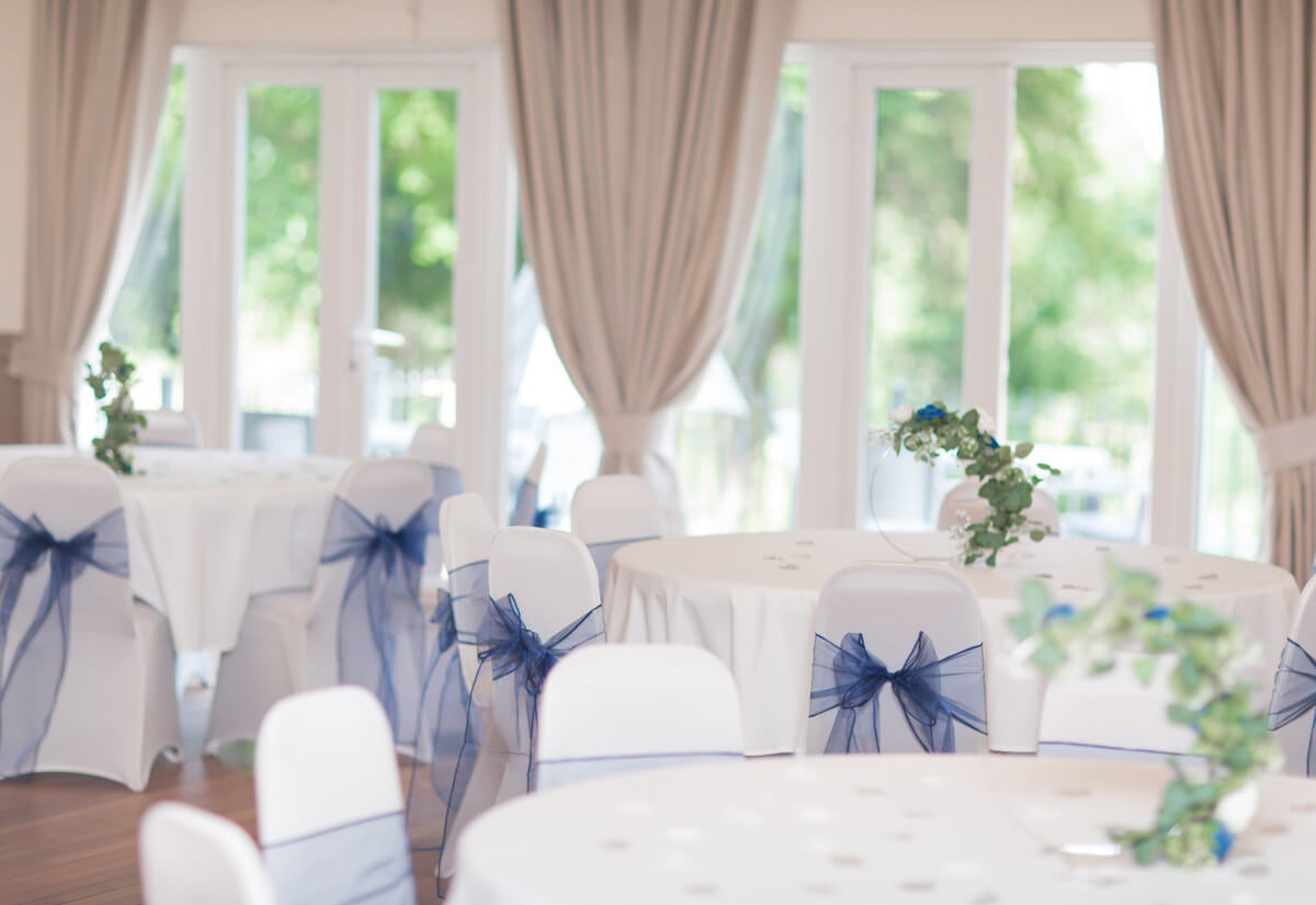 Elegant wedding venue with round tables and navy blue sashes in Surbiton.