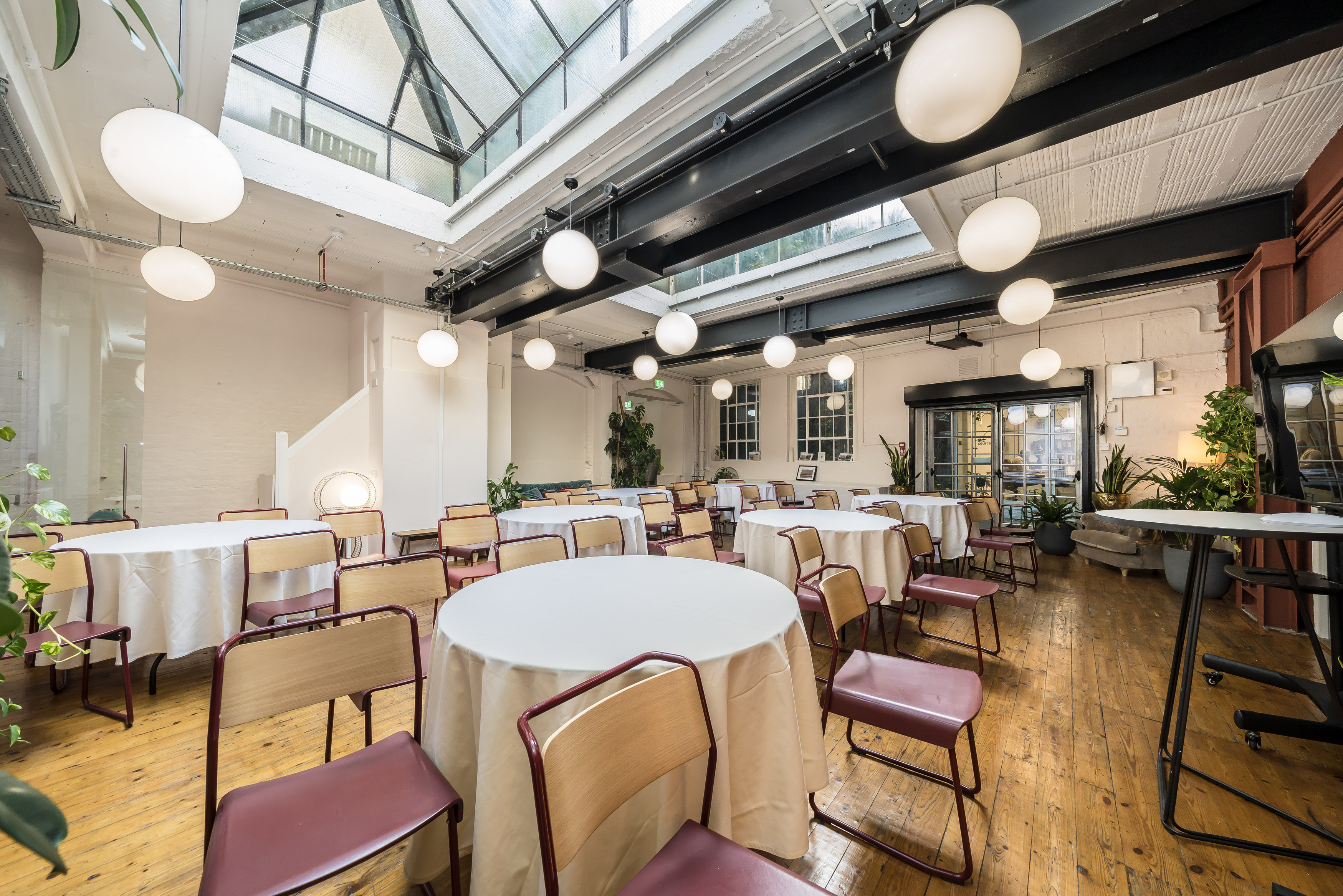 Elegant event space at Menier Playhouse with round tables and modern lighting.