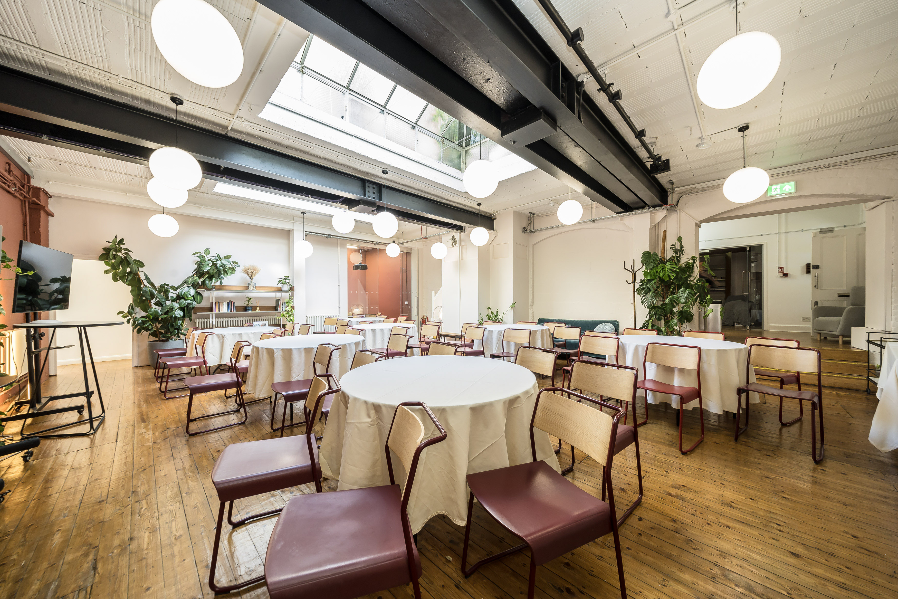 Versatile event space at Menier Playhouse with round tables, ideal for workshops and receptions.