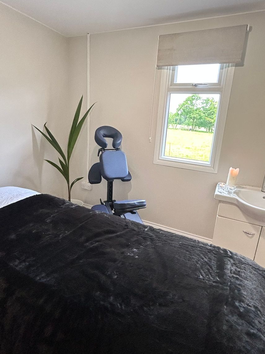 Nail desk in serene treatment room with massage chair for wellness events and relaxation.