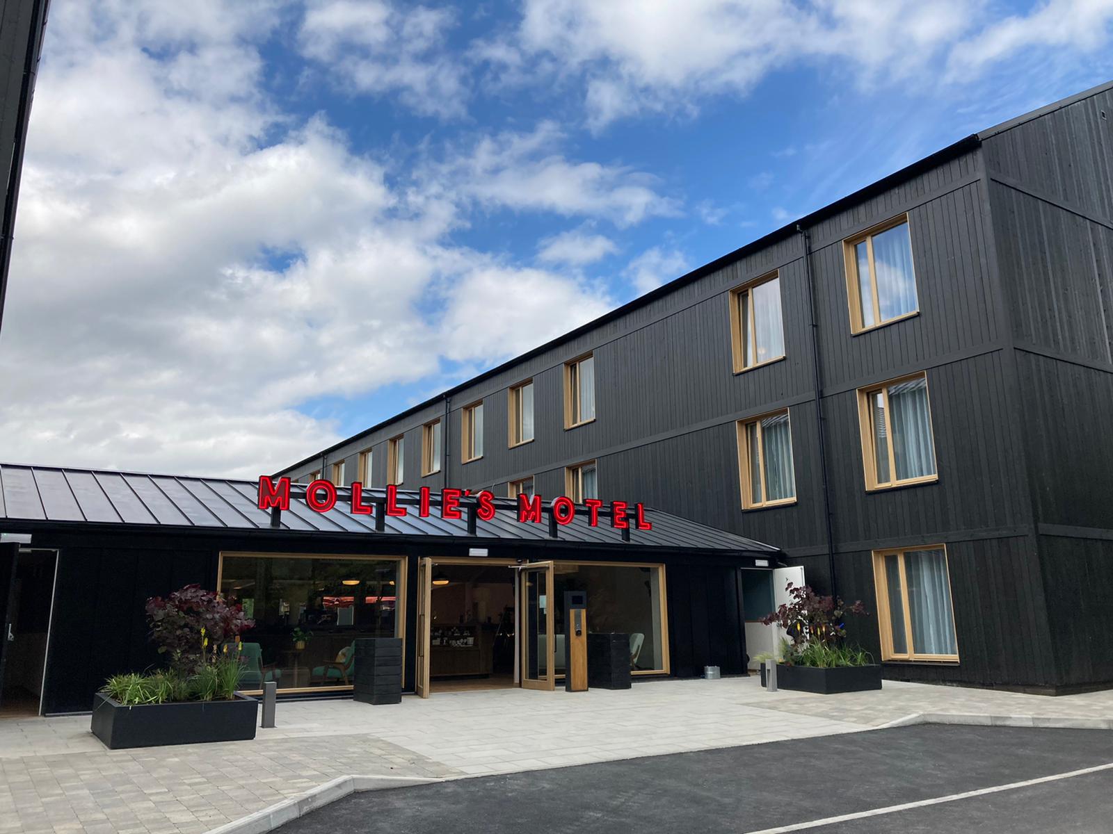 Modern hotel exterior with sleek black wood paneling, ideal for corporate events.