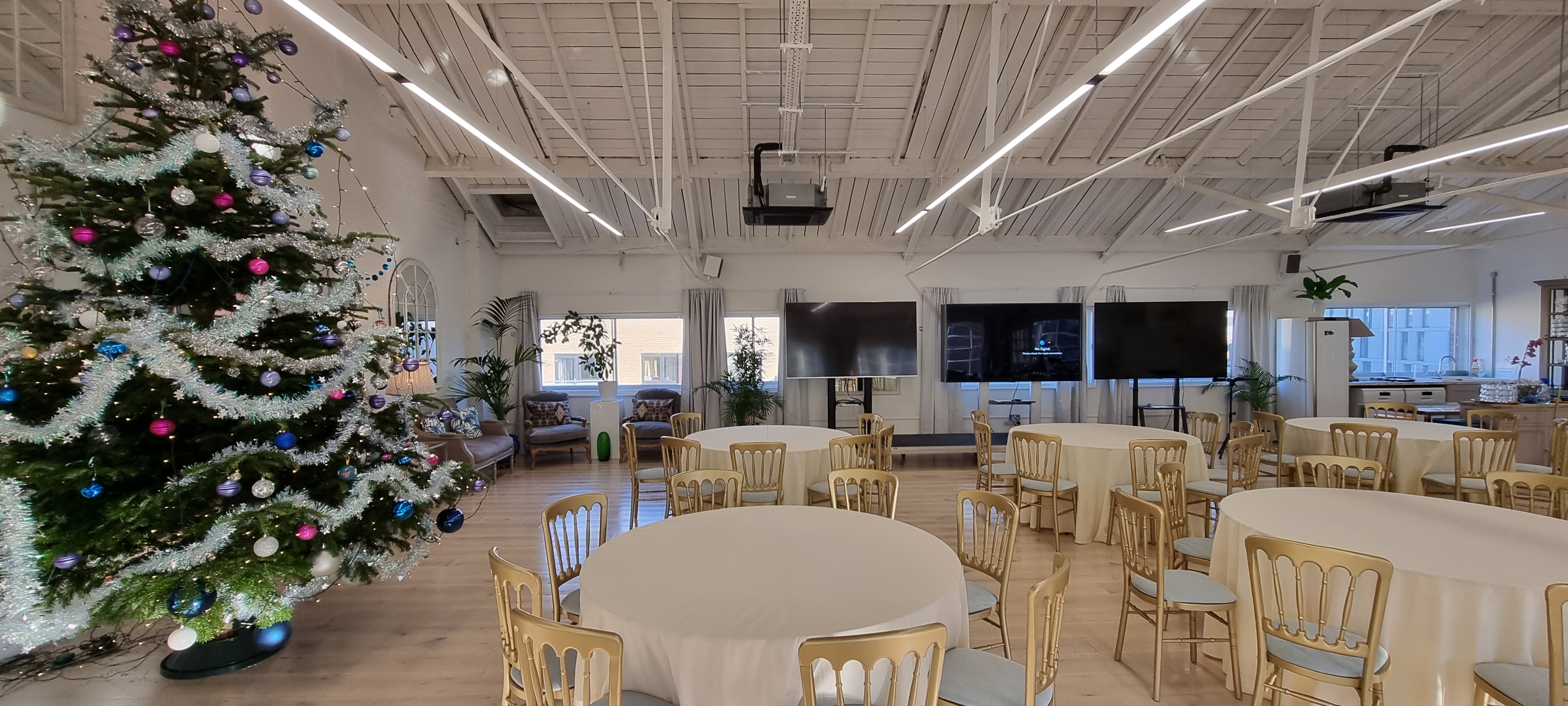 Elegant event space with round tables, perfect for holiday gatherings and corporate meetings.