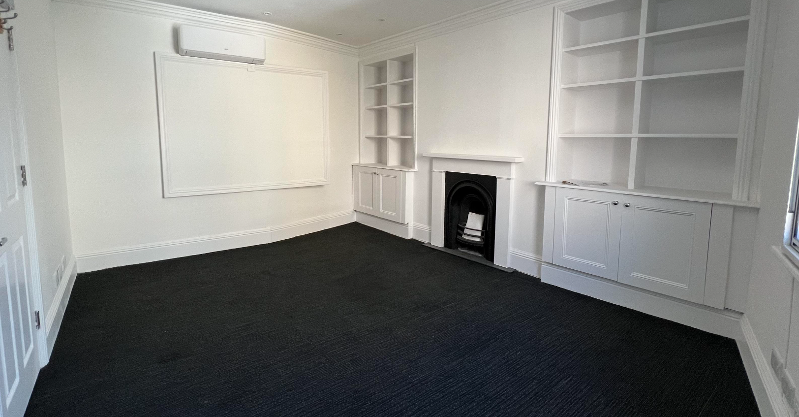 Well-lit meeting room in Feelium with white walls, ideal for workshops and presentations.