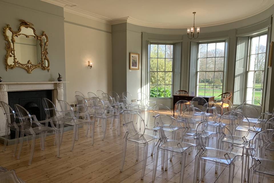 Elegant Holcombe Room with transparent chairs, ideal for workshops and gatherings.