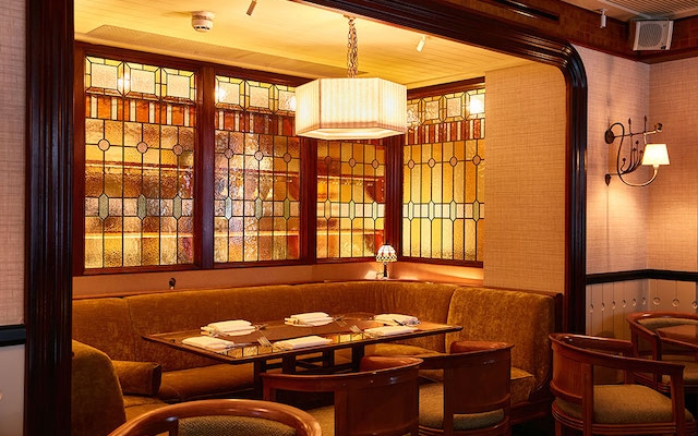 Cozy dining area with stained glass windows, perfect for networking events or private dinners.