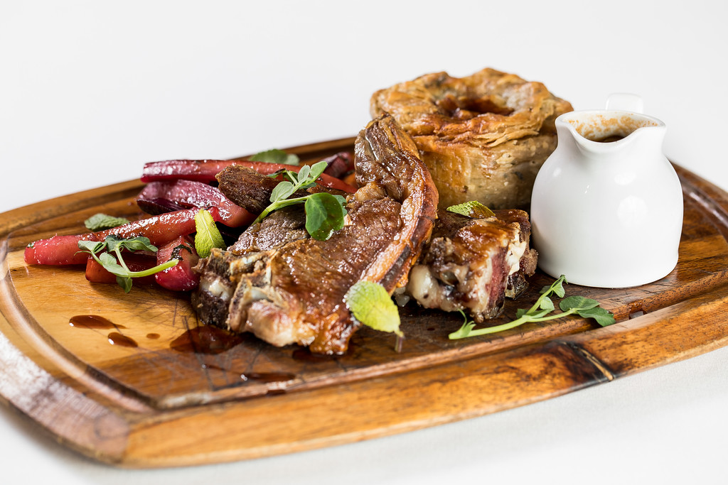 Succulent meat dish with roasted vegetables at Tudor Barn Eltham Gastro Pub. Fine dining.
