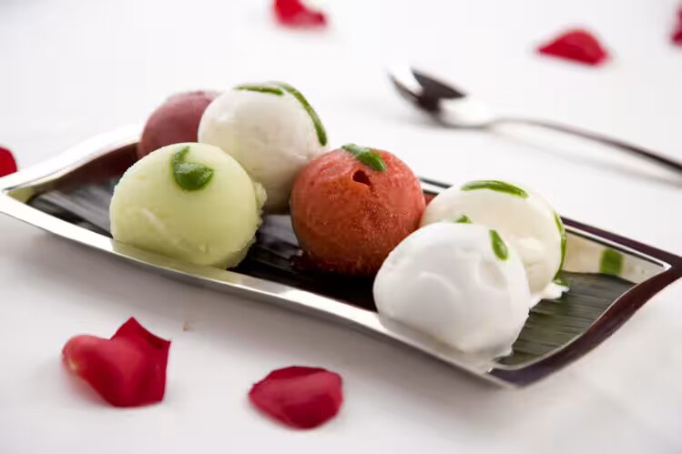 Elegant sorbet dessert with herbs and rose petals at Zari Restaurant for upscale events.
