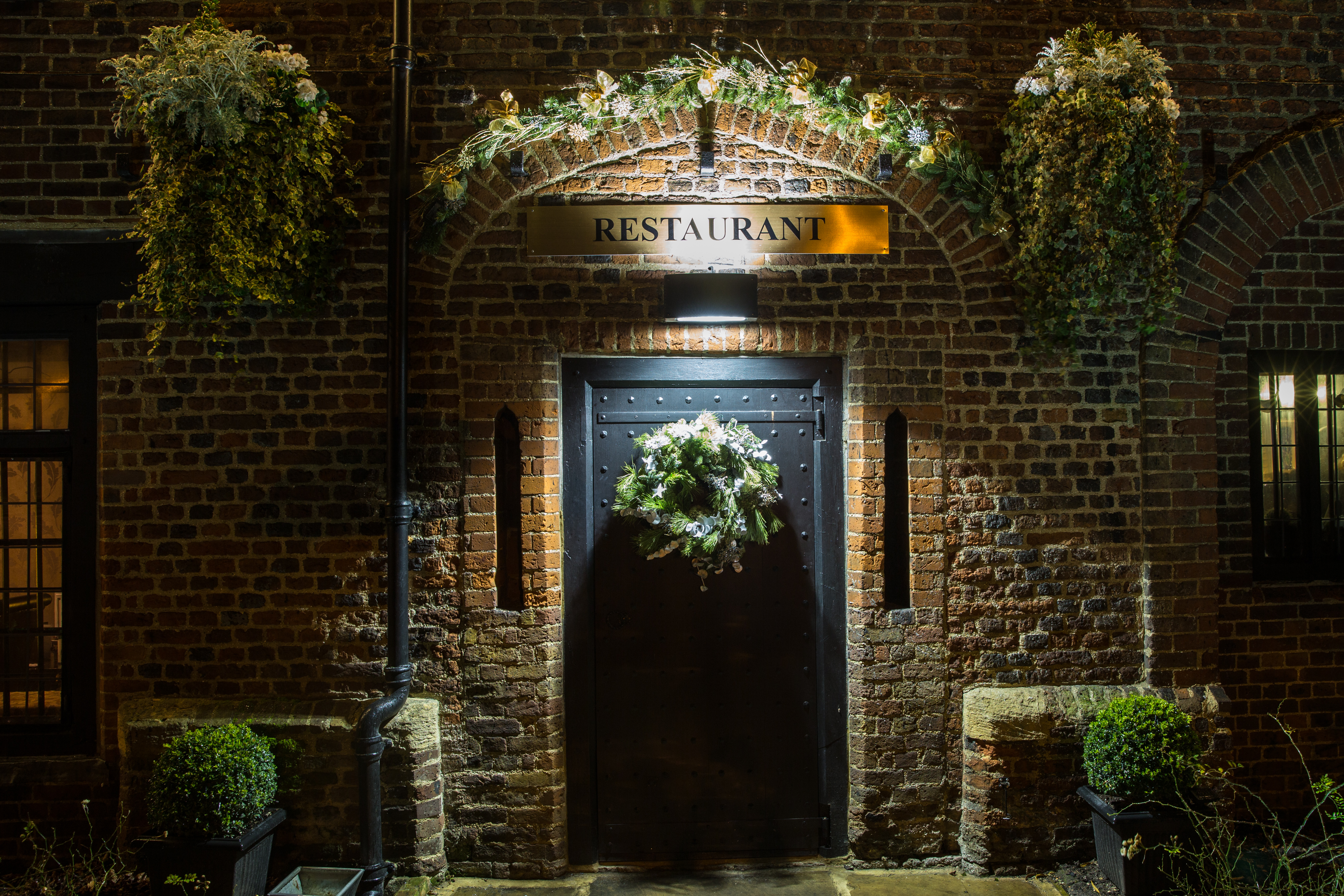 Gastro Pub entrance at Tudor Barn Eltham, adorned with flowers for upscale events.
