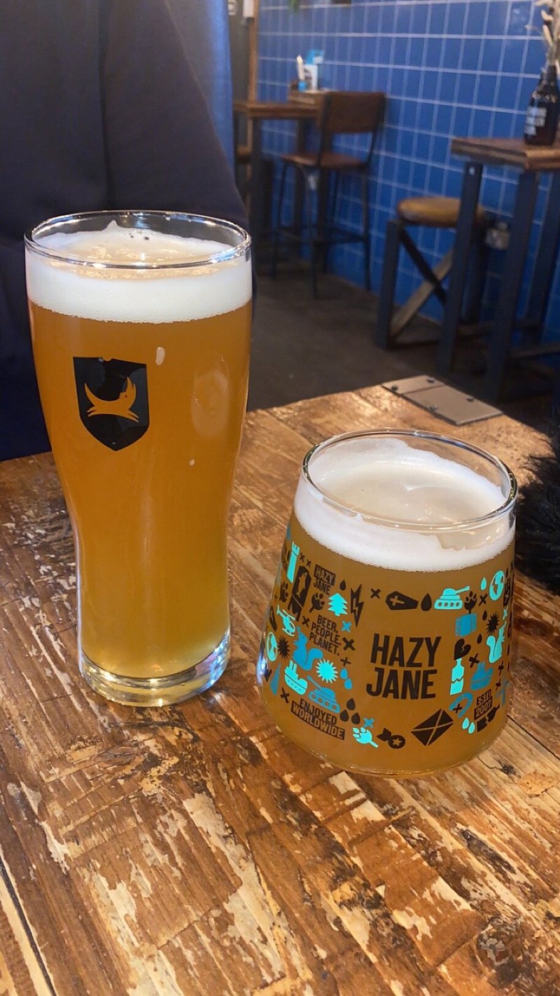 Craft beers on rustic table at BrewDog Edinburgh beer garden for networking events.