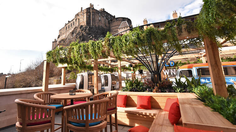 Beer garden at BrewDog Edinburgh with lush greenery, perfect for summer events.