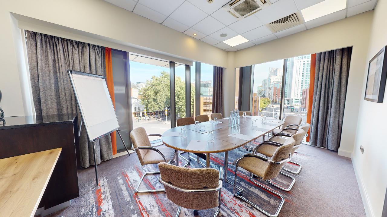 Modern meeting room with large table and city view at Clayton Hotel Cardiff. Ideal for workshops.