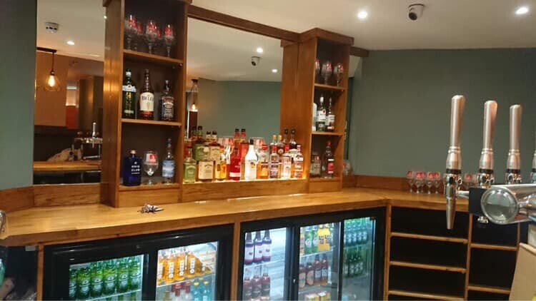 Well-stocked bar with polished wood, perfect for events and social gatherings.