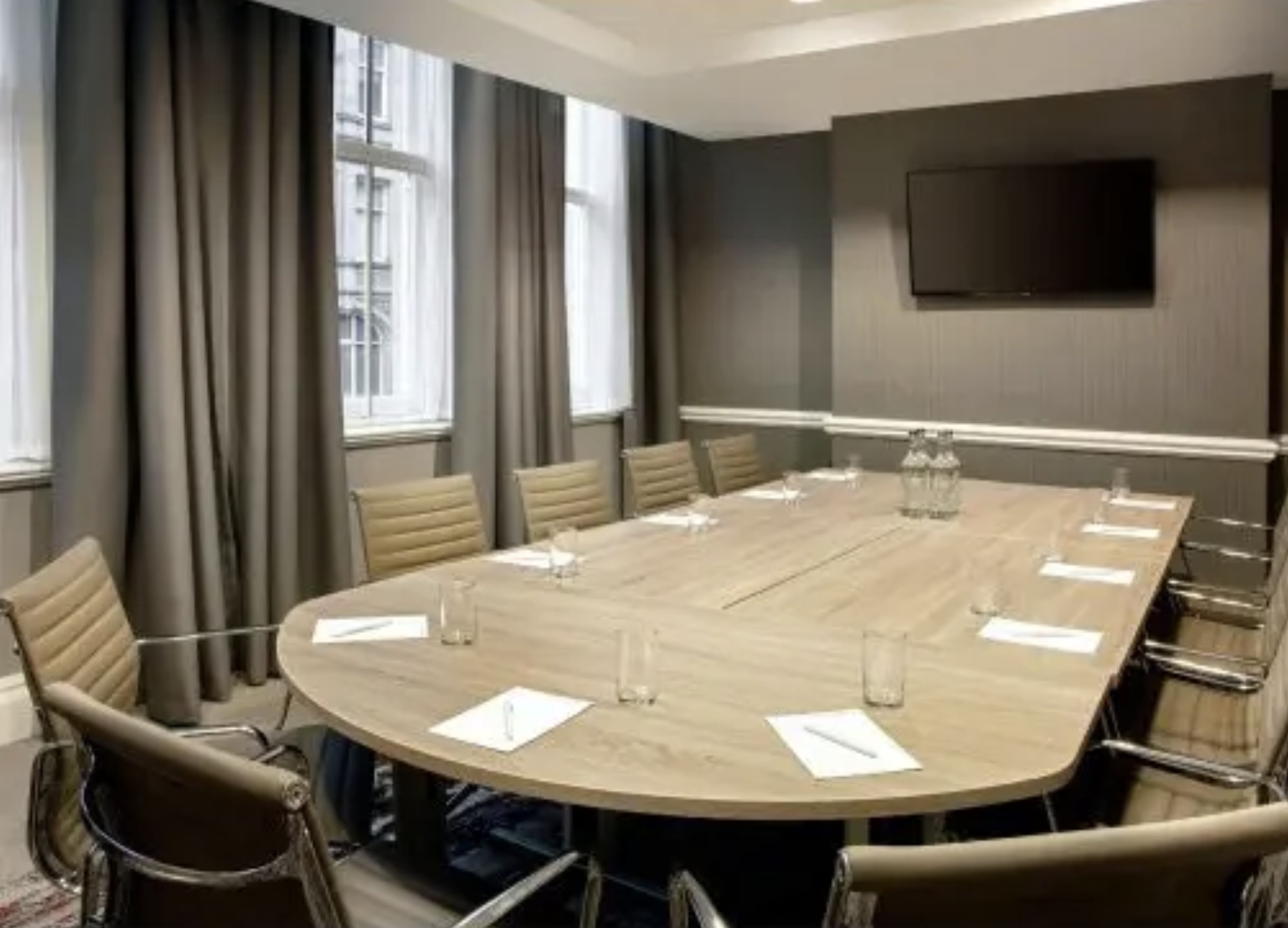 Modern conference room in Leonardo Hotel Cardiff with oval table for meetings.