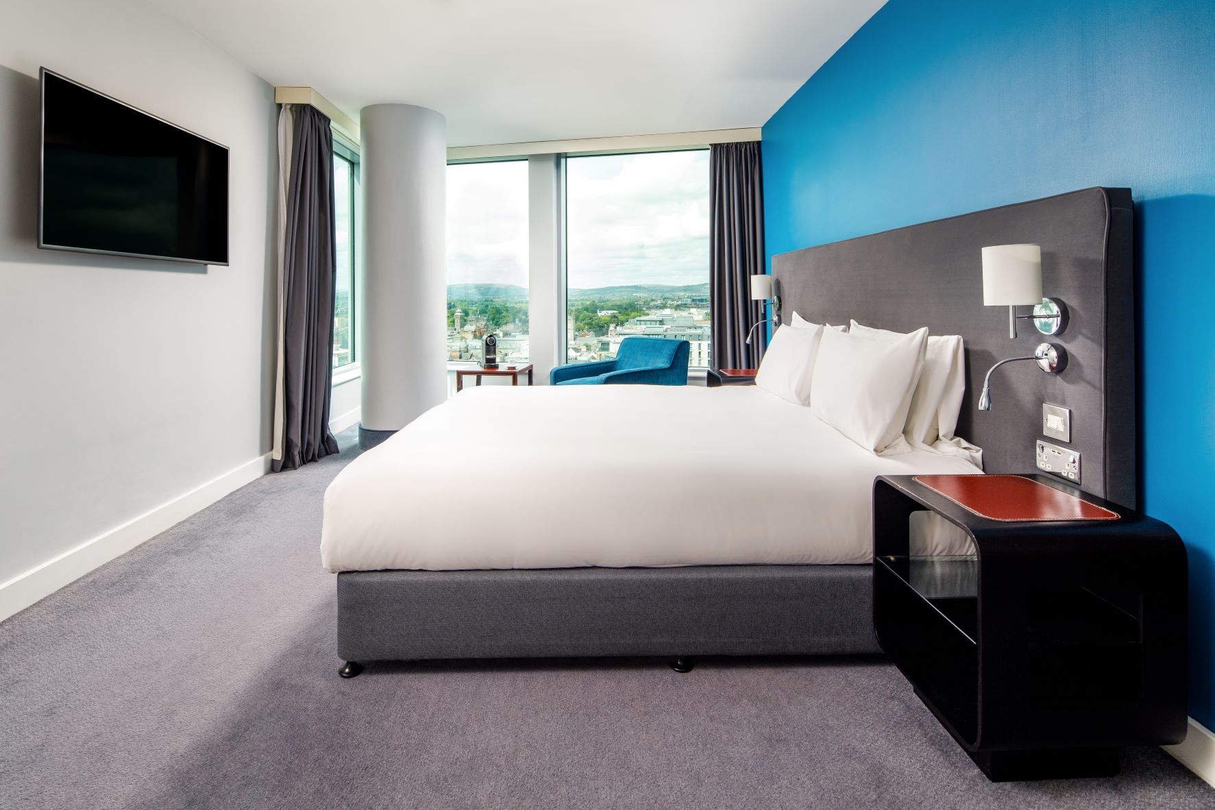 Modern hotel room with king-sized bed in Radisson Blu Cardiff for events and relaxation.