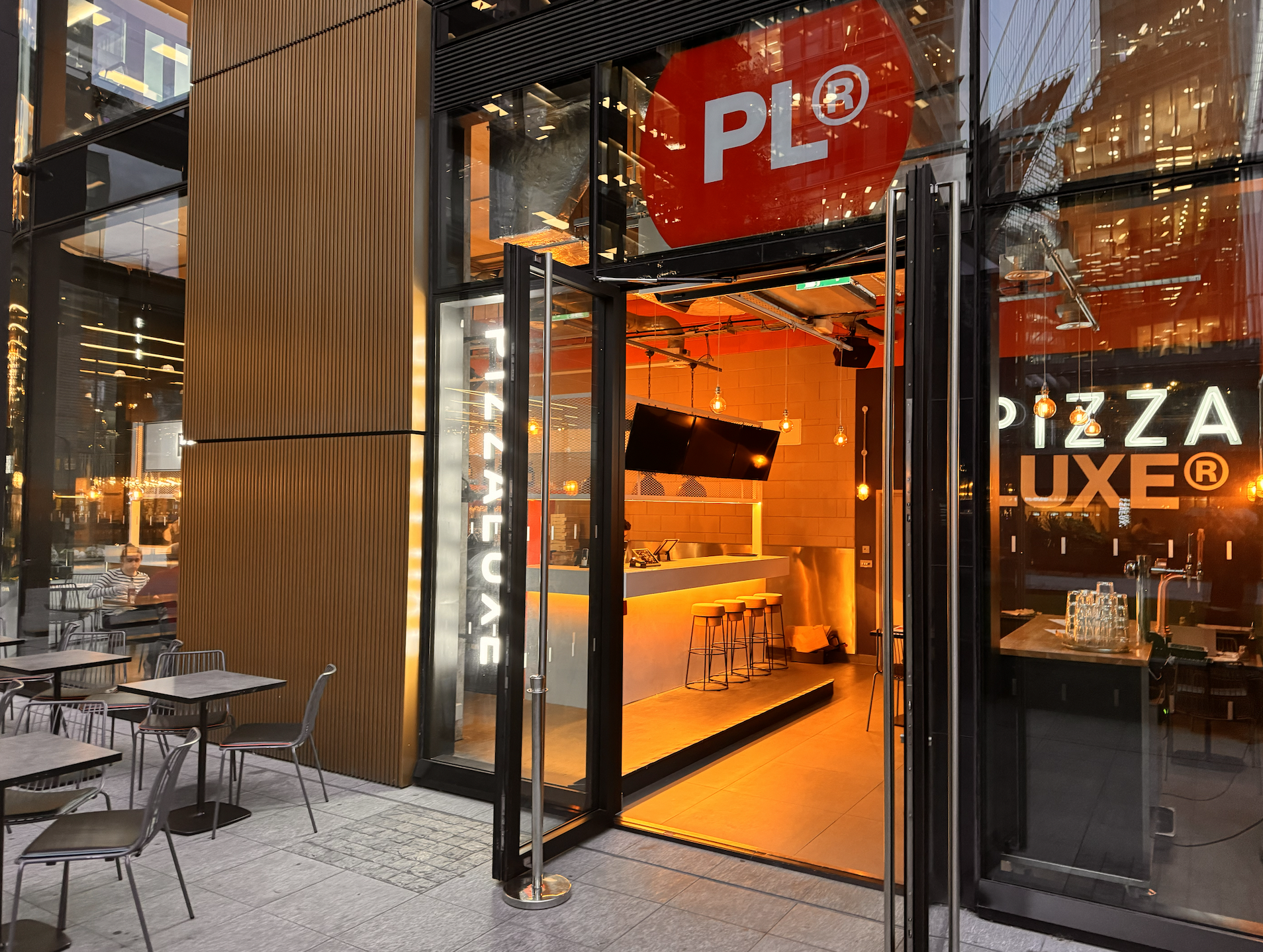 Modern pizza restaurant entrance at PizzaLuxe, ideal for networking events and casual meetings.